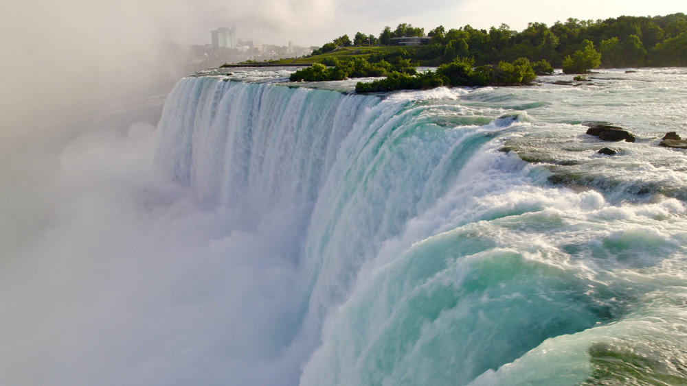 Water cascades over the crest of Niagara Falls.