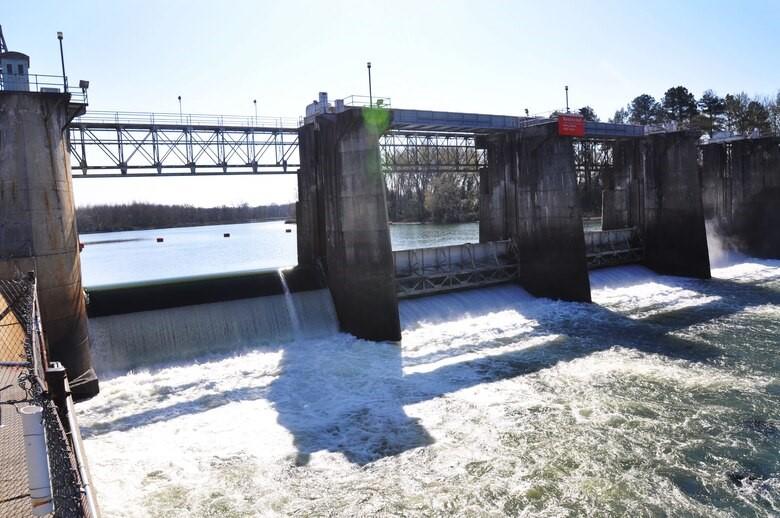 Water is shown falling over a dam on a river.