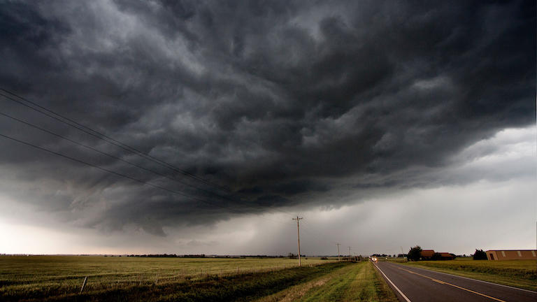 A dark storm over an isolated rural road.