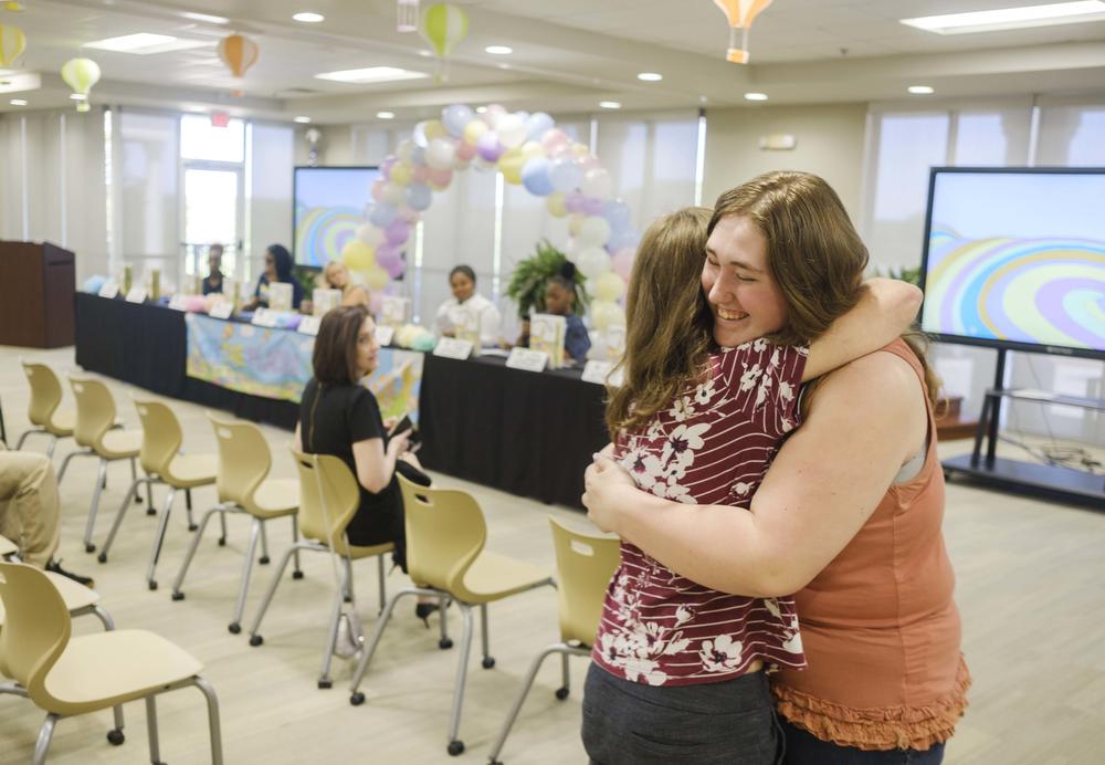 Alexa Pasquale of Forsyth's Mary Persons High School hugs her former teacher Jennifer Hogan before the start of a ceremony celebrating the graduation of Pasquale and others from the Teaching as a Profession career track. 