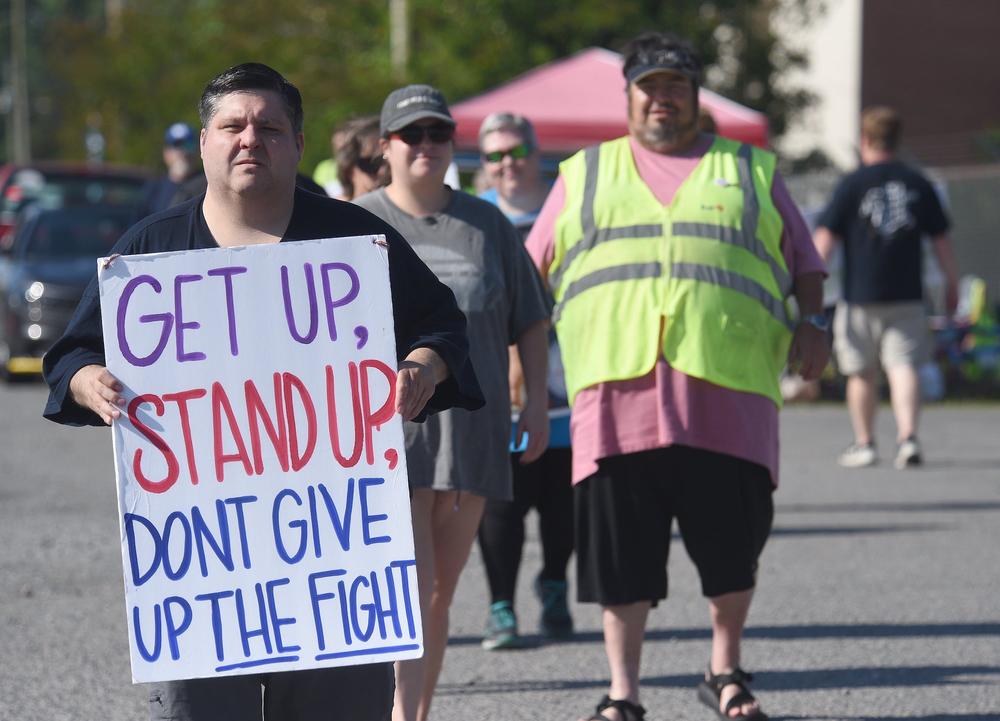 Chris Crowe, left, carries a sign during the protest by Amalgamated Transit Union Local 1212 in front of First Student in Dalton on Monday, May 15, 2023. Crowe is vice president of ATU Local 1212.