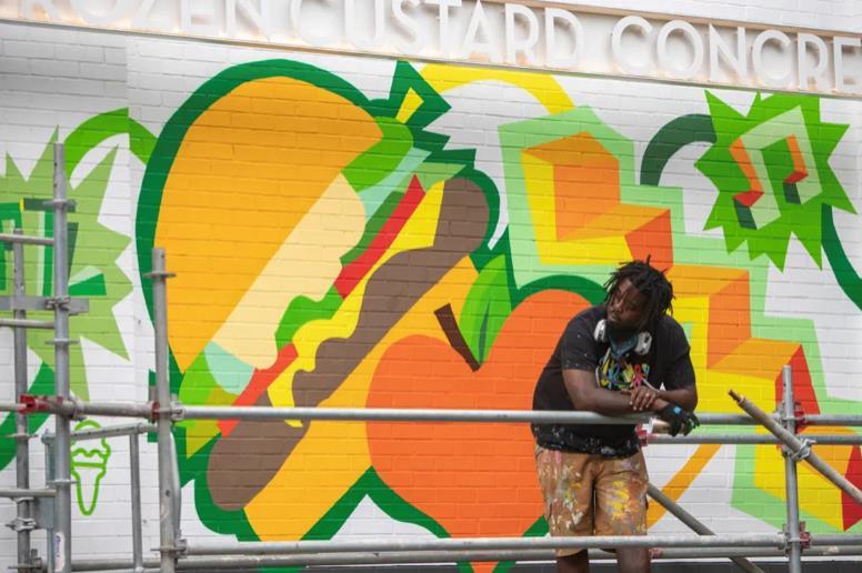 Bongang in front of his midtown mural. 