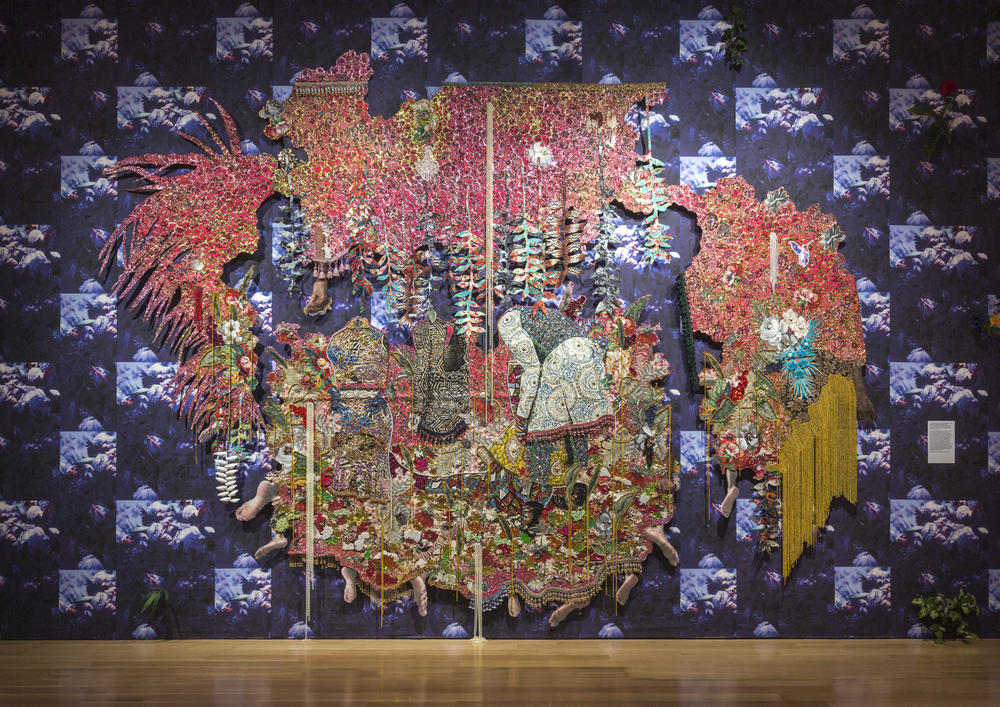 Ebony G. Patterson (Jamaican, born 1981), ...they stood in a time of unknowing...for those who bear/bare witness, 2018, hand-cut jacquard woven photo tapestry with glitter, appliques, pins, embellishments, fabric, tassels, brooches, acrylic, glass pearls, beads, and hand cast heliconias, High Museum of Art, Atlanta, purchase with funds from D. Lurton Massee Jr. Endowment for Contemporary Art, Friends of Contemporary Art, and Stan Cohen, 2022.253. © Ebony G. Patterson. Photo courtesy of the artist.