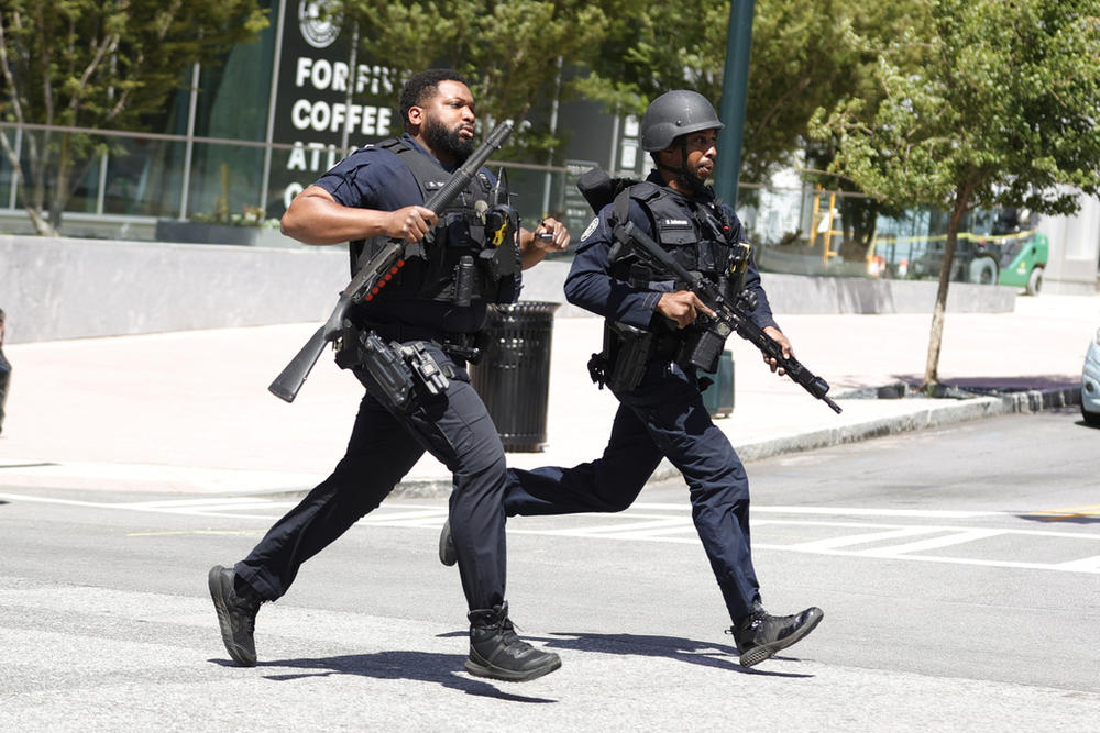 Law enforcement officers run near the scene of an active shooter on Wednesday, May 3, 2023 in Atlanta. Atlanta police said there had been no additional shots fired since the initial shooting unfolded inside a building in a commercial area with many office towers and high-rise apartments. 