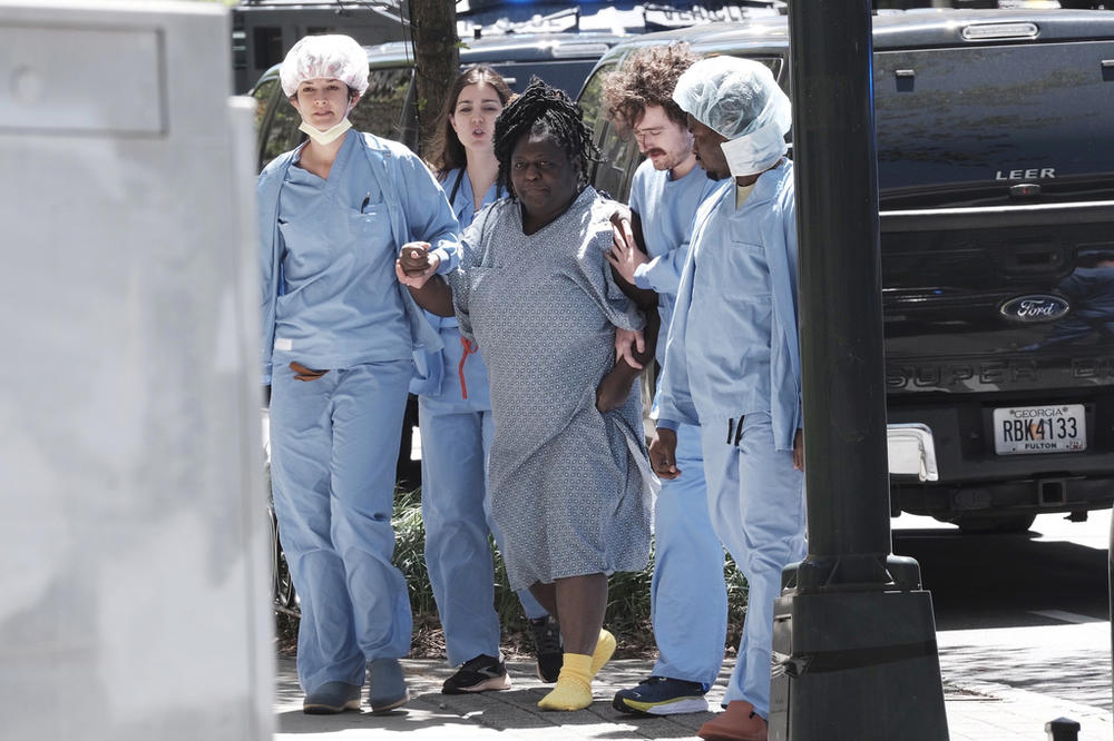 A medical patient is helped away from the scene of an active shooter on Wednesday, May 3, 2023 in Atlanta. Atlanta police said there had been no additional shots fired since the initial shooting unfolded inside a building in a commercial area with many office towers and high-rise apartments. 