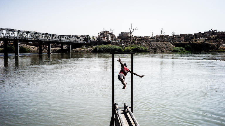 A man dives into a lake.