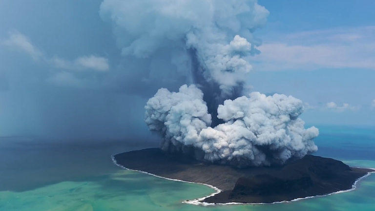 A volcano erupting on a pacific island.