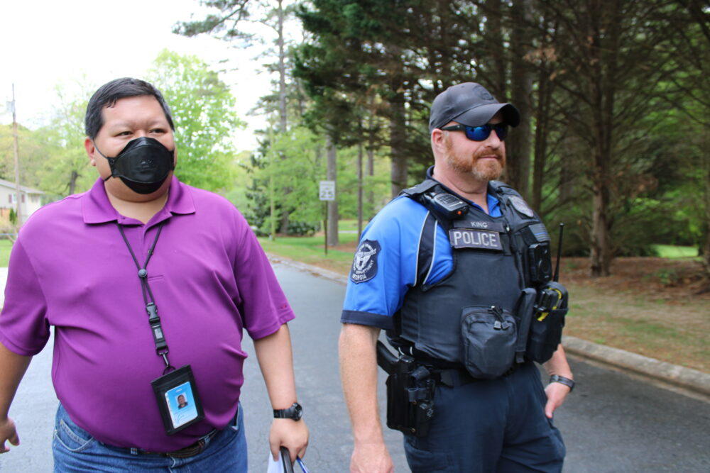 Matthew Dames and Officer Jacob King walk back to their patrol car after checking in with a Cobb County resident they met who had a previous mental health crisis on April 14, 2023. 
