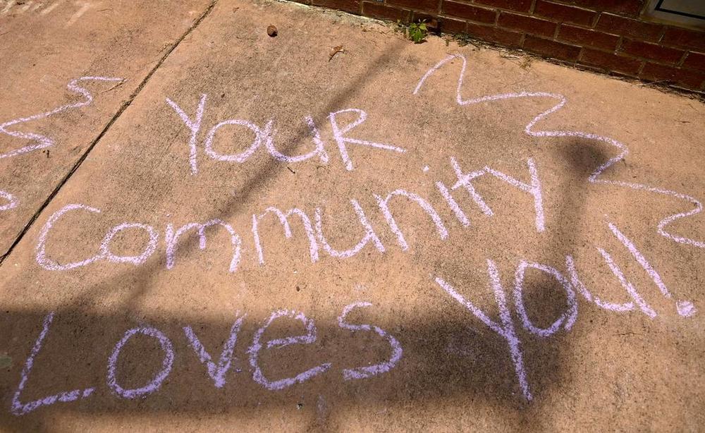 A chalk drawing reads “Your Communty Loves You” across from Temple Beath Israel as hundreds of people gather at for a counter-protest Saturday afternoon after an antisemitic hate group gathered outside the Temple Friday. 