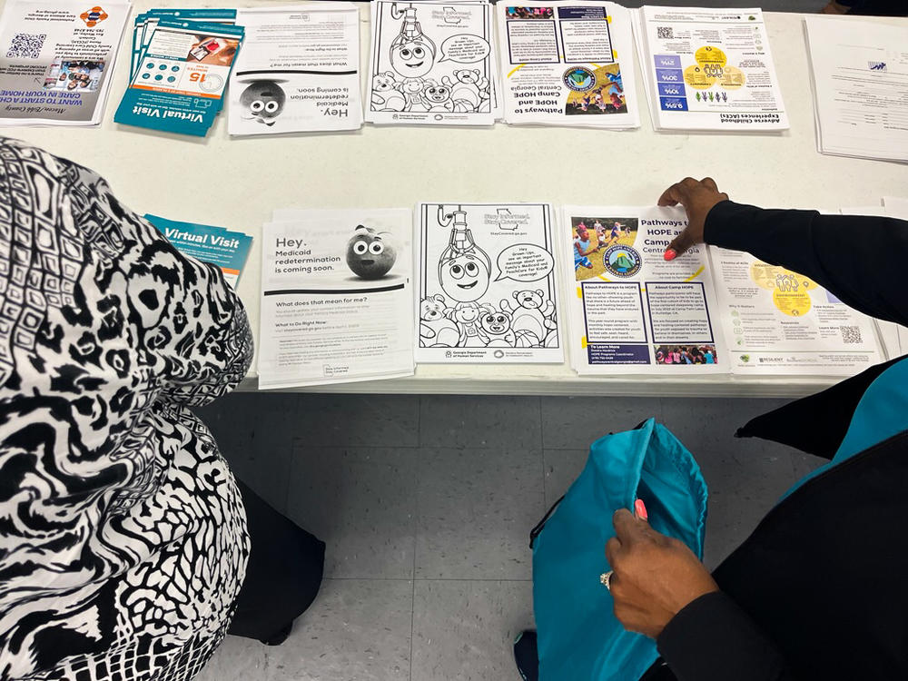 Volunteers at a stakeholder meeting in Macon pick up fliers from Georgia's "Stay Covered" website,  run by the Georgia Department of Human Services and the Georgia Department of Community Health.