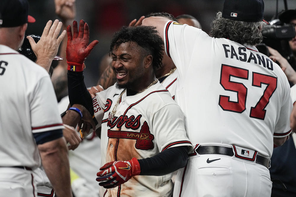 Atlanta Braves' Ozzie Albies, center, celebrates after hitting a winning three-run home run in the 10th inning of a baseball game against the New York Mets, Thursday, June 8, 2023, in Atlanta.