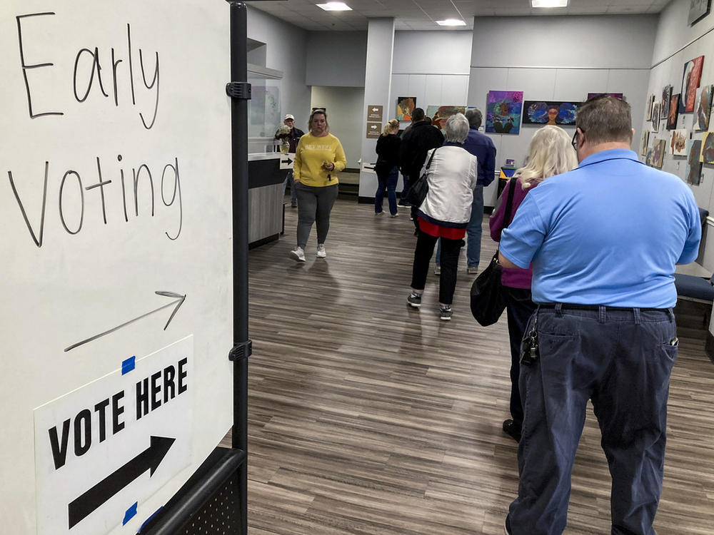 People wait in line to early vote for the U.S. Senate runoff election in Georgia between Sen. Raphael Warnock and challenger Herschel Walker, on Nov. 28, 2022, in Kennesaw, Ga., near Atlanta. After years of criticizing mail voting and trying to ban so-called "ballot harvesting," Republicans are reversing course. They are poised to launch aggressive get-out-the-vote campaigns for 2024 that employ just those strategies.