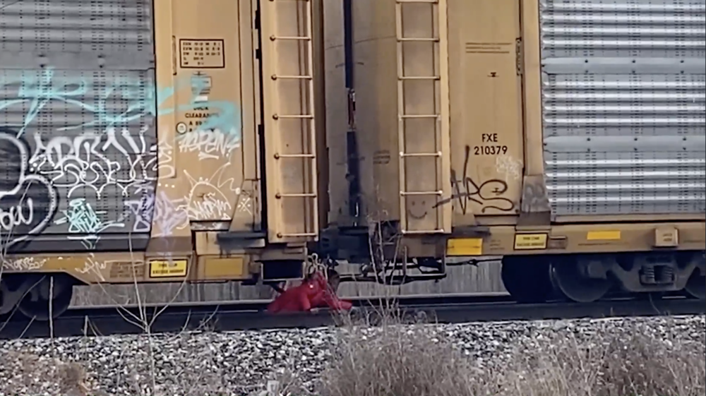  A girl crawls under the train with her backpack. Credit: Gray Television/InvestigateTV 