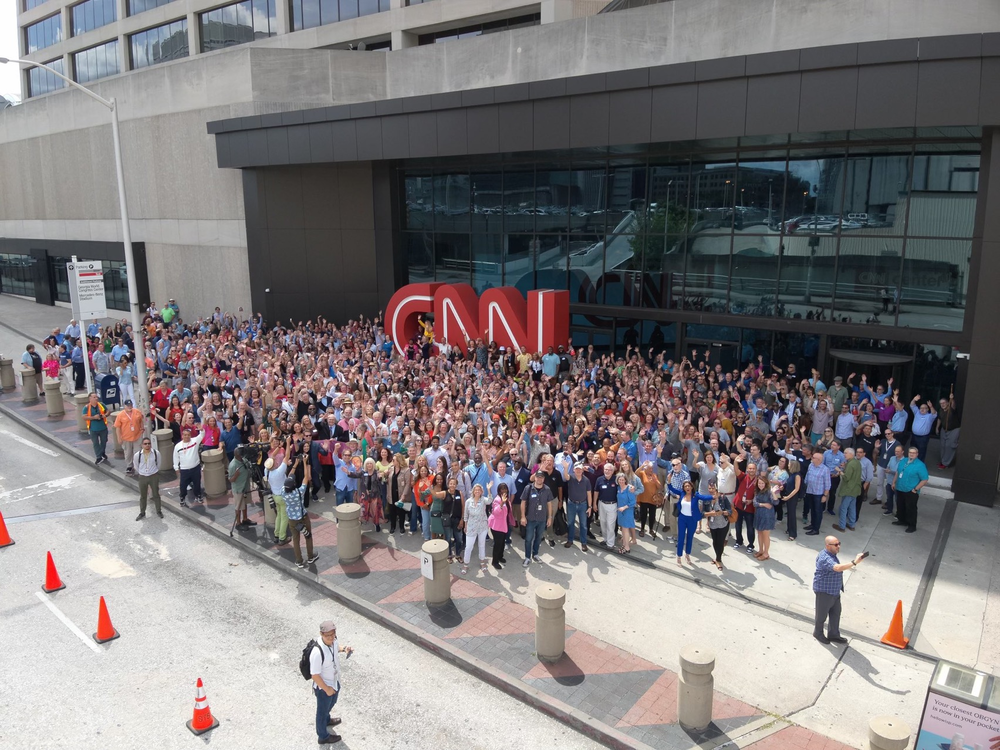 Current and former CNN employees gather in front of the iconic red letters on June 1, 2023 to mark the network's 43 years. The sign will be moved to the company's Techwood location this year.