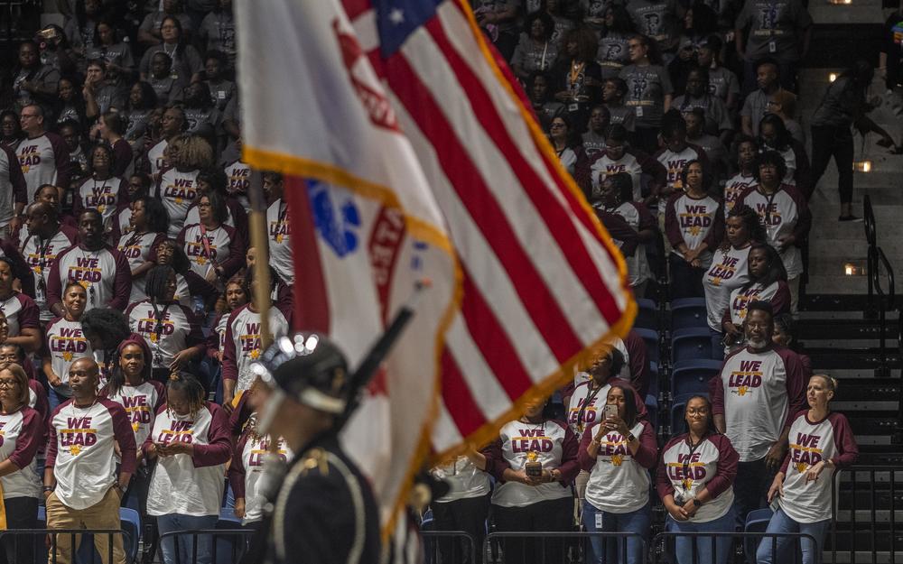 Teachers from Northeast High School stand for the presentation of colors at the start of the Bibb County School District's convocation ceremony Tuesday. 