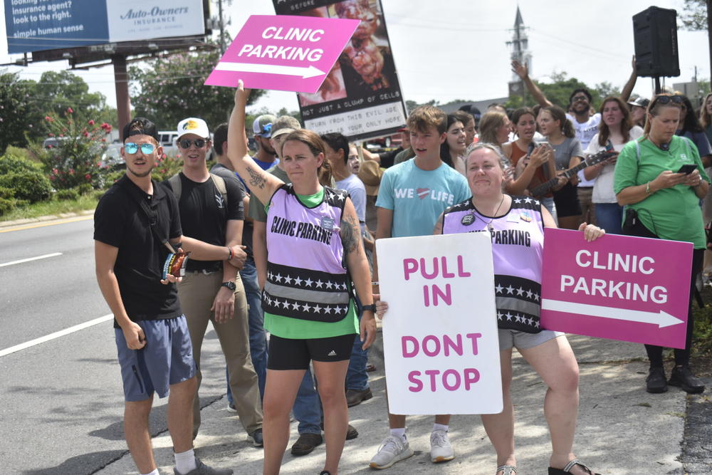 Abortion rights volunteers attempt to stand between potential patients and anti-abortion protesters.