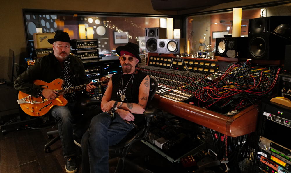 Songwriter/Screenwriter/Actor Billy Bob Thornton sitting in a studio with a man holding a guitar.