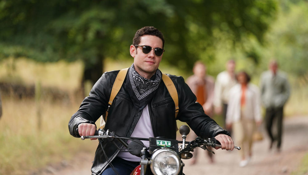 Tom Brittney as Will Davenport in “Grantchester” riding a motorcycle.