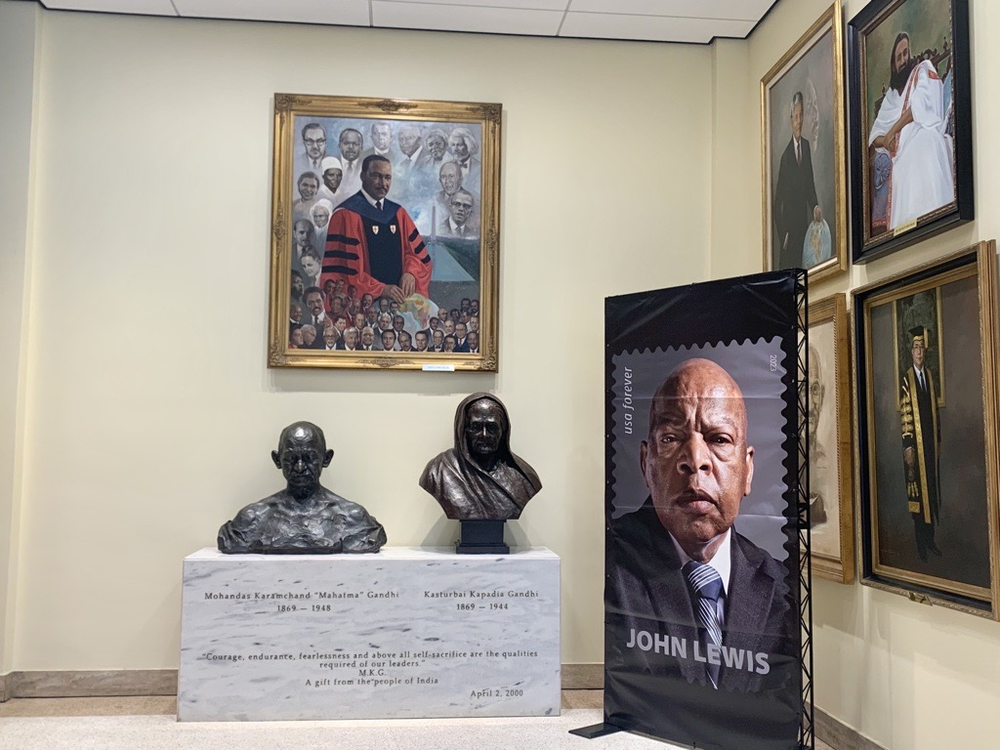 A banner featuring the John Lewis stamp sits next to a painting of Martin Luther King, Jr. and a bust of Gandhi at Morehouse College in Atlanta on July 21, 2023.