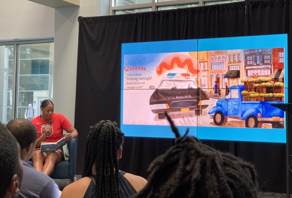 Former Atlanta Dream player Kia Vaughn reads Little Blue Truck Leads the Way written by Alice Schertle and illustrated by Jill McElmurry during a Mayor’s Summer Reading Club event at Georgia Public Broadcasting. Credit: Devon Zwald