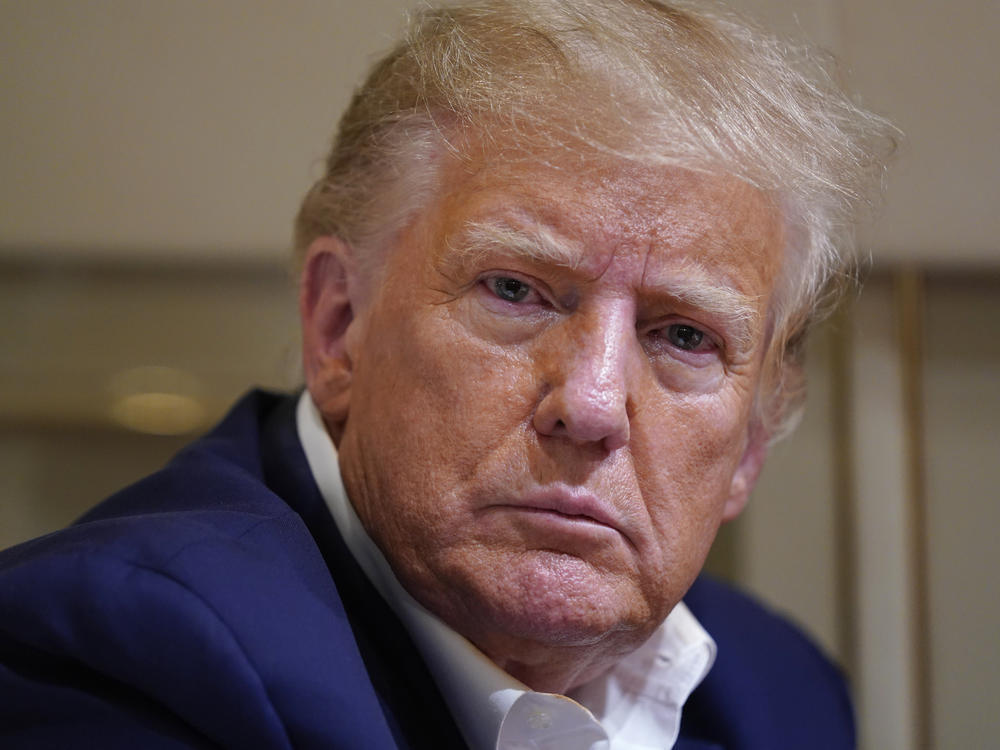 Former President Donald Trump listens as he speaks with reporters while in flight on his plane after a campaign rally at Waco Regional Airport, in Waco, Texas, March 25, 2023, while en route to West Palm Beach, Fla.