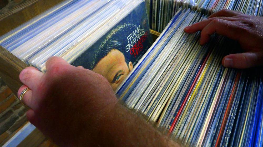 Brian Cook, the owner of Blue Canary Records in Columbus, Georgia, flips through his extensive selection of Frank Sinatra records. 