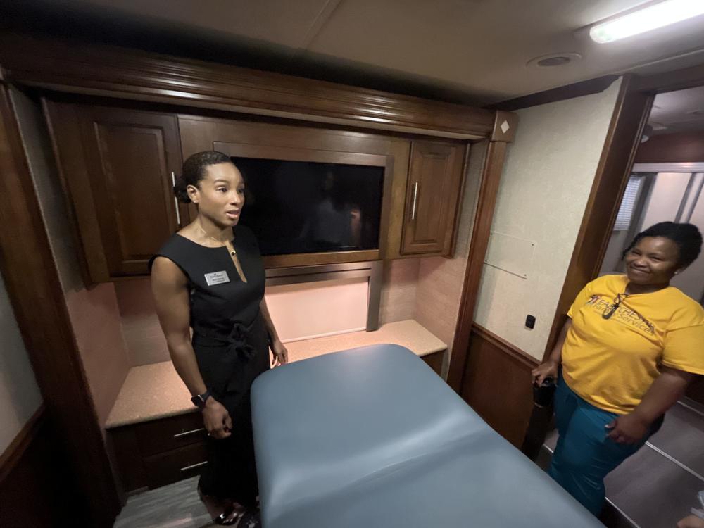 Ariel Esteves (left), vice president of clinical operations with CareSource, gives a tour of the exam room on board a mobile clinic. CareSource Georgia and its partner Eastchester Family Services are using the clinic to help people keep their Medicaid coverage.