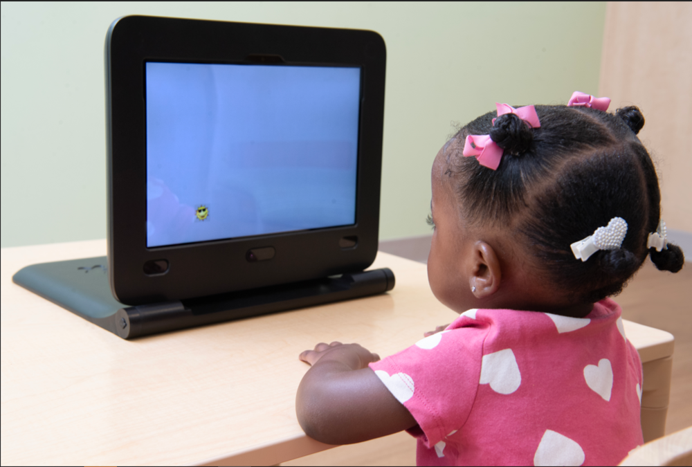 A young girl watches a screen