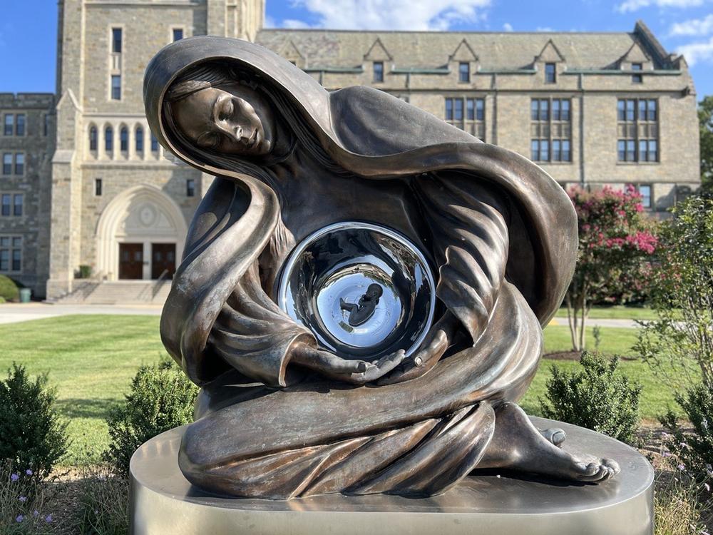 Canadian sculptor Timothy Schmalz says Advent is a representation of Jesus as a fetus, resting in a woman made of mystical material that represents God’s creation. His largest version, known as the National Life Monument, was blessed by a group of male Catholic leaders at the Catholic University of America on May 17, 2023. 