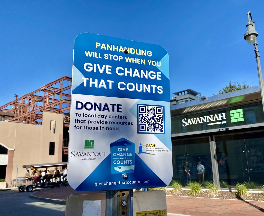 A sign posted near Ellis Square in downtown Savannah is part of a campaign by the city and a local homelessness nonprofit to solicit donations for four day centers.