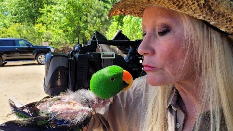 Sharon Collins holding a parrot.