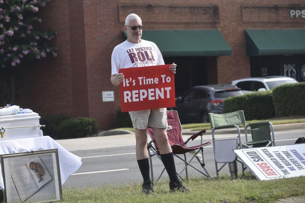 Anti-abortion protester stands in the grassy median outside A Preferred Women’s Health Care Center of Atlanta in Forest Park.