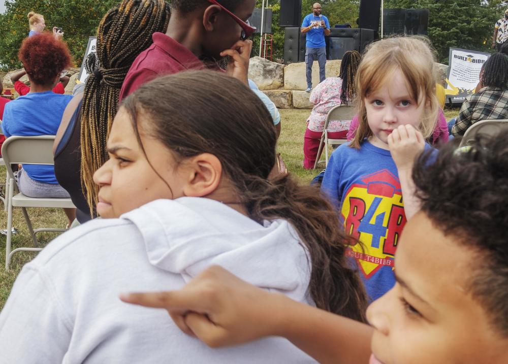 Bibb County Schools students, foreground, while Superintendent Dan Sims, background, speaks at the first of half a dozen  after school fairs held to promote school attendance.