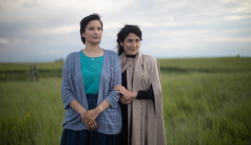 Two women standing in a field.