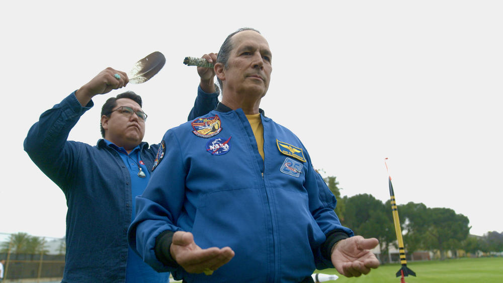 Aerospace engineer Aaron Yazzie (Navajo) smudges astronaut John Herrington (Chickasaw) with an eagle feather that flew with Herrington on the Space Shuttle.