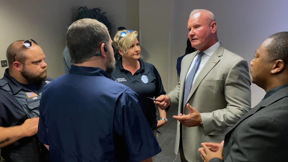 Stoney Mathis, second from right, speaks with law enforcement officers Monday morning. 