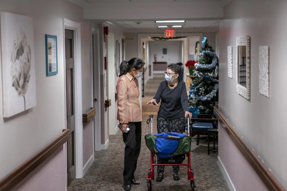 Tina Sandri, CEO of Forest Hills of DC senior living facility, left, helps resident Courty Andrews back to her room, Dec. 8, 2022, in Washington. The federal government will, for the first time, dictate staffing levels at nursing homes, the Biden administration said Friday, Sept. 1, 2023, responding to systemic problems bared by mass COVID deaths.