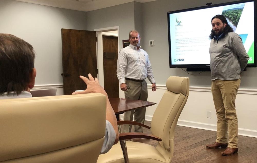 At October’s Macon-Bibb County Industrial Authority meeting, Macon Water Authority Chairman Gary Bechtel, left, asks Mayor Pro Tem Seth Clark about regulations governing national parks. (Liz Fabian)