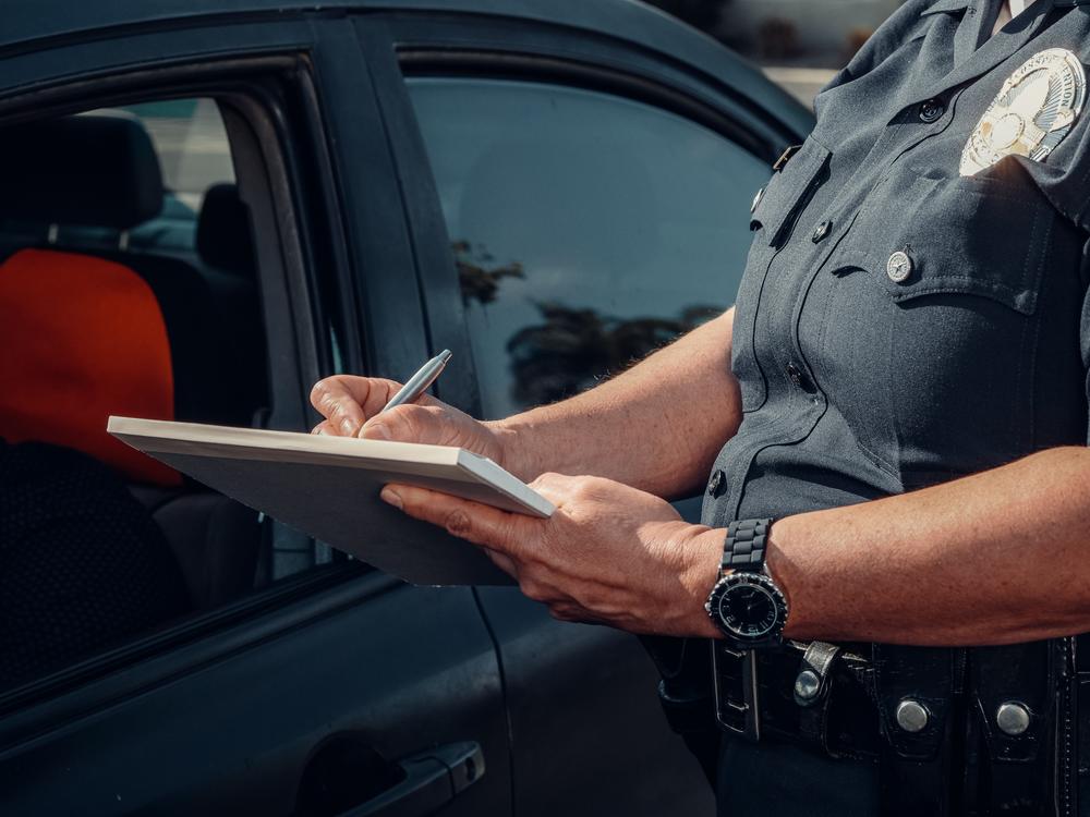 Close up of a police officer writing a speeding ticket.
