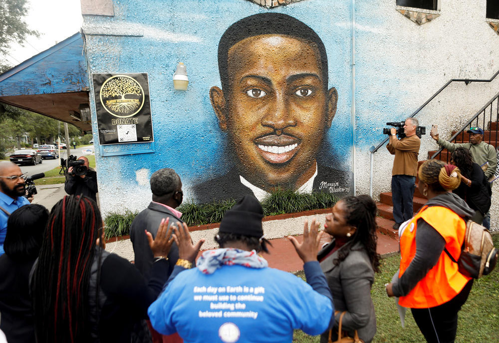 People gather in front of a mural of Ahmaud Arbery painted on the side of The Brunswick African American Cultural Center demanding justice for Ahmaud Arbery in Brunswick, Georgia, November 4, 2021. 