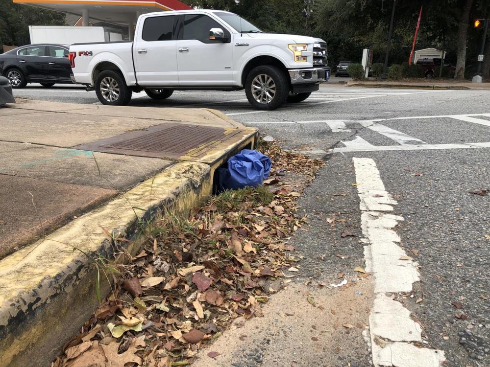 A discarded pair of medical scrubs blocks the storm drain near the intersection of College and Forsyth streets. (Liz Fabian)