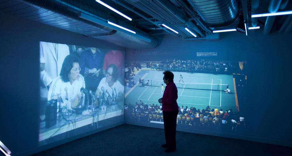 Groundbreakers host Billie Jean King watching footage of her iconic “Battle of the Sexes” competition with Bobby Riggs in 1973.