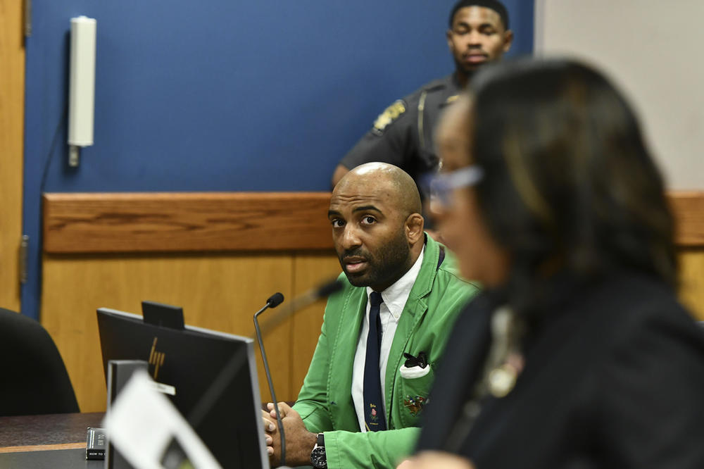 Defendant Harrison Floyd, left, a leader in the organization Black Voices for Trump, listens as Fulton County District Attorney Fani Willis addressed the court during a hearing related to the Georgia election indictments, Tuesday, Nov. 21, 2023, in Atlanta. Fulton County Superior Court Judge Scott McAfee heard arguments Tuesday on a request to revoke Floyd's bond, of one of former President Donald Trump's co-defendants in the Georgia case related to efforts to overturn the 2020 election. 