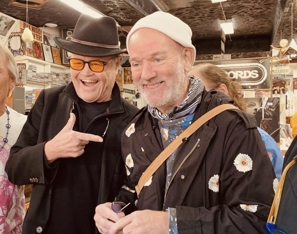 Micky Dolenz (left) and Michael Stipe, former members of legendary bands the Monkees and R.E.M., respectively,  joke inside inside Wuxtry Records in Athens, Ga., on Nov. 3, 2023. Dolenz was in town to promote his new EP, Dolenz Sings R.E.M.
