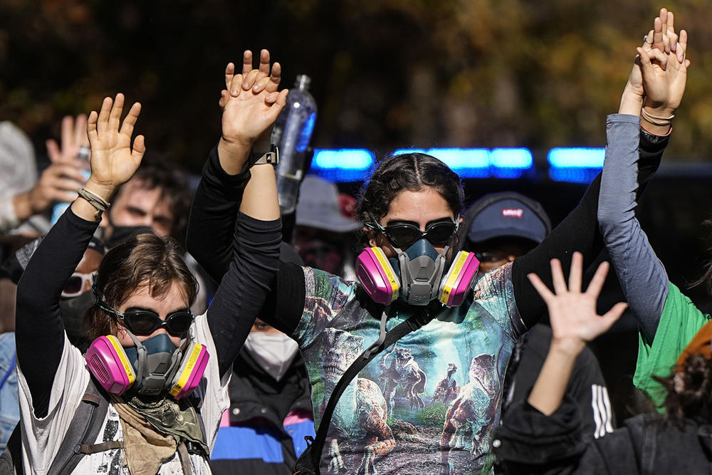 Protesters leave a wooded area after gas was used during a demonstration in opposition to a new police training center, Monday, Nov. 13, 2023, in Atlanta. 