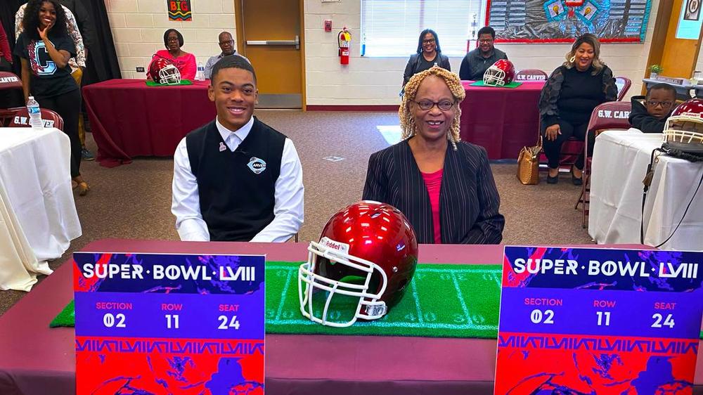 Carver High School junior Braylon Jakes, left, learned during Friday’s assembly that the NFL is providing two tickets for him and a guest to attend Super Bowl LVIII in Las Vegas. Here, Jakes and his grandmother Jacqueline Jakes are answers questions after the event. 11/03/2023 Mike Haskey mhaskey@ledger-enquirer.com  