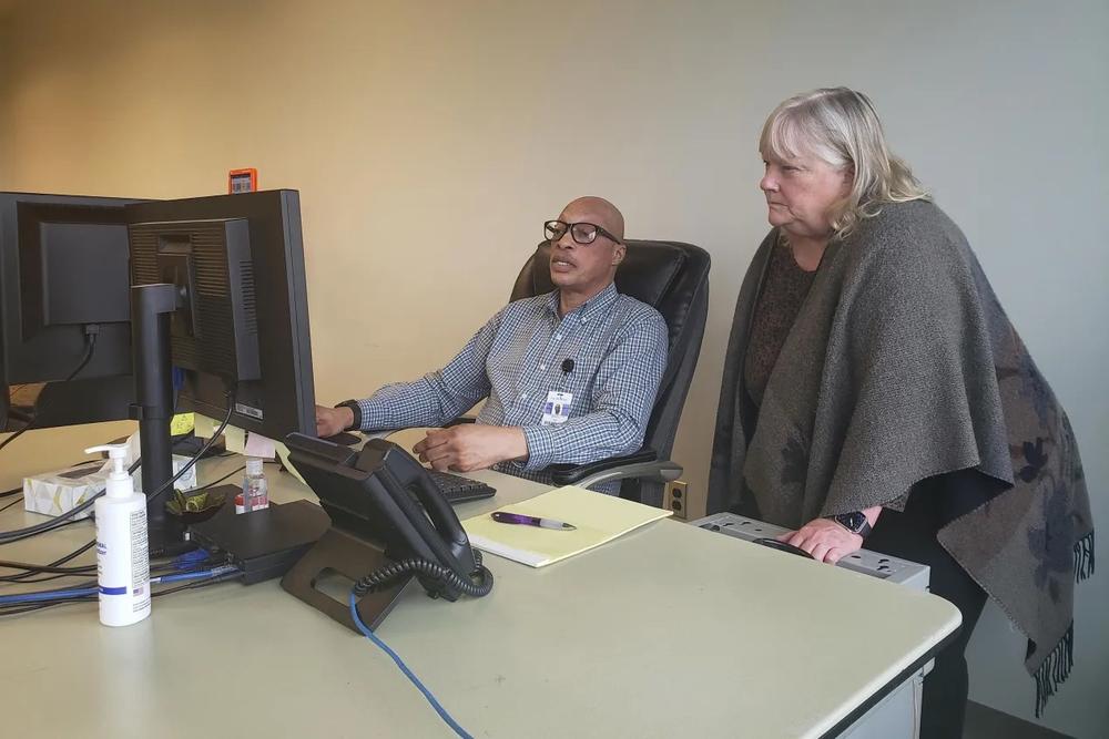 On May 4, 2023, Jody White (left) and Grace Burke of Morton Comprehensive Health Services in Tulsa, Oklahoma, examined a list of the health center’s patients whose Medicaid eligibility was up for review that month. White had spent the morning calling patients on the list to make sure they were aware of the process and offer his assistance.