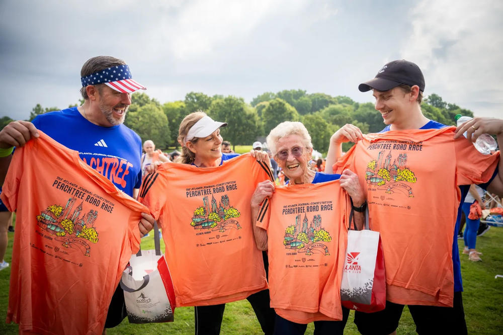 Participants holding 2023 Finisher’s Shirt for the AJC Peachtree Road Race.