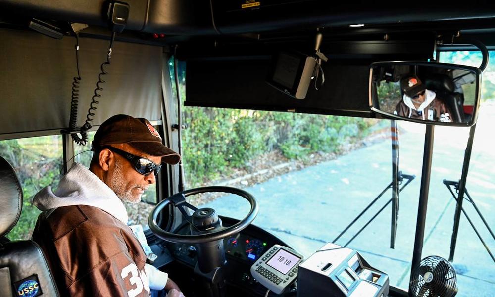MTA bus driver Vernon Franklin, 67, speaks with a customer at a bus stop along his route. Franklin has been driving a bus for MTA for almost 16 years.  