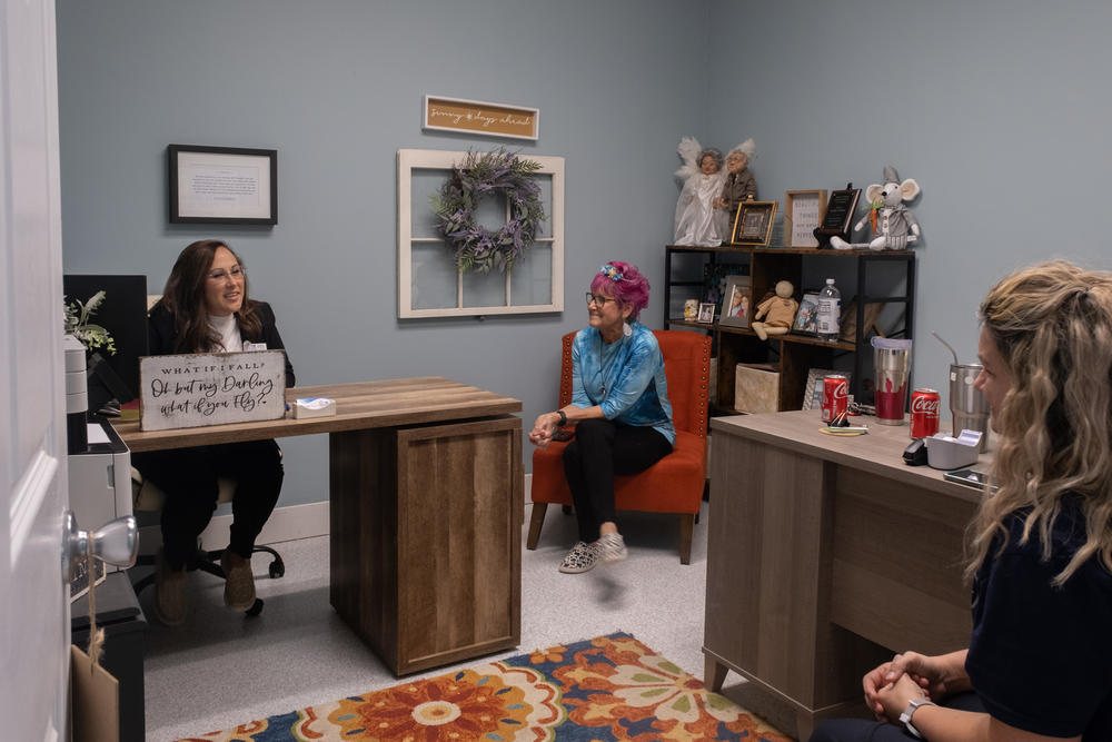 Jocelyn Wallace sits in her office with Cyndi Burnett and Candi Florence, both volunteers at The Never Alone Clubhouse. Recovery Community Organizations like this one are run almost entirely by people who have dealt with substance use disorder.